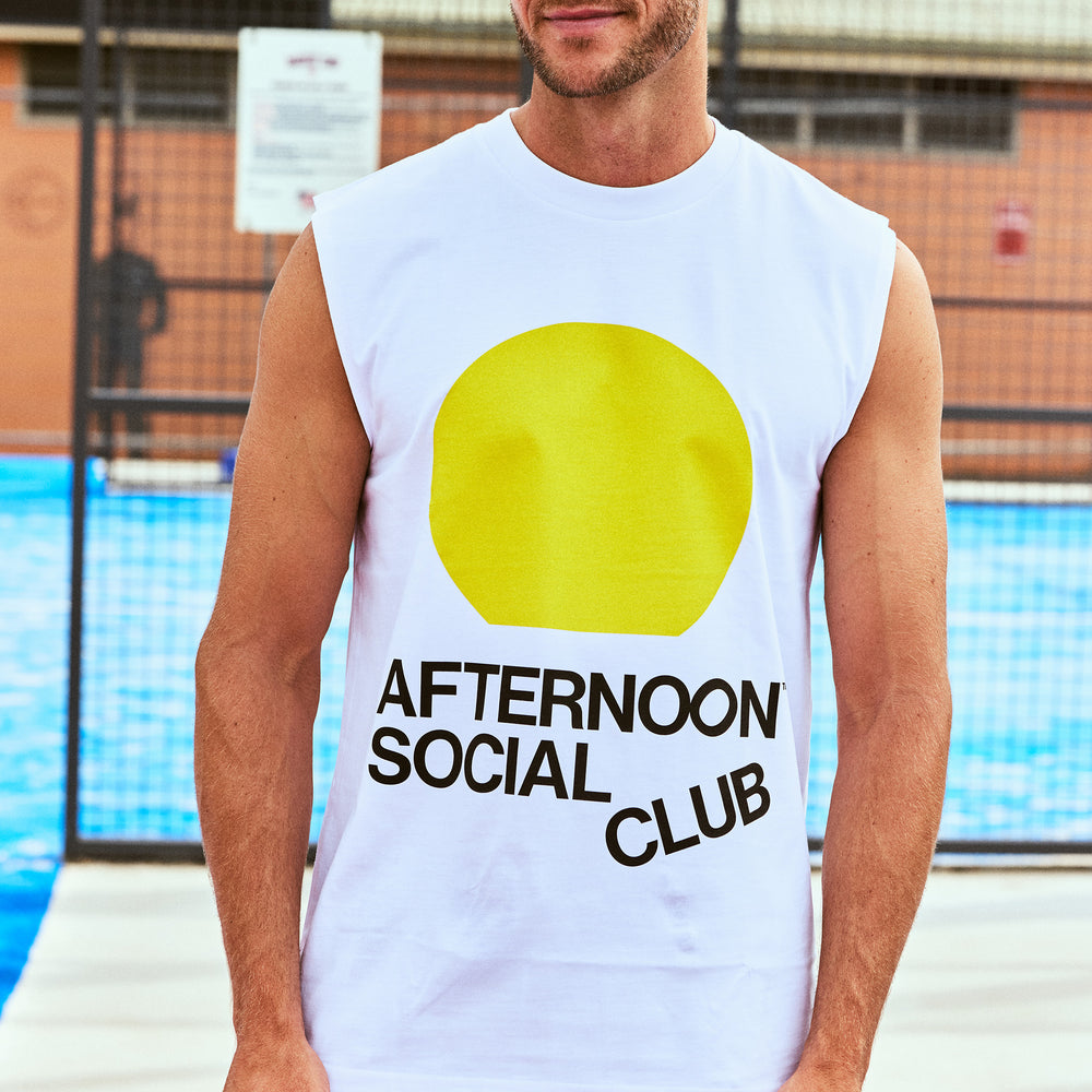 male model wearing white tank top with yellow sunset circle and Afternoon Social Club lettering on front.
