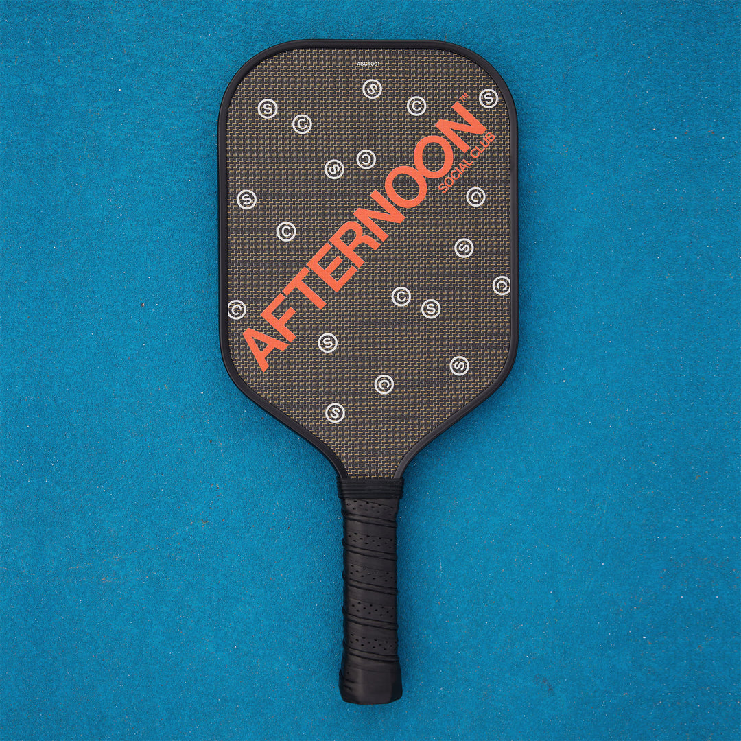 Black titan carbon pickleball paddle featuring the words Afternoon SC in orange and white 