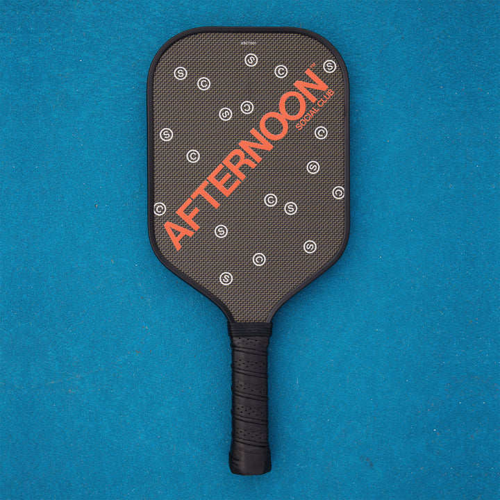 Black titan carbon pickleball paddle featuring the words Afternoon SC in orange and white 