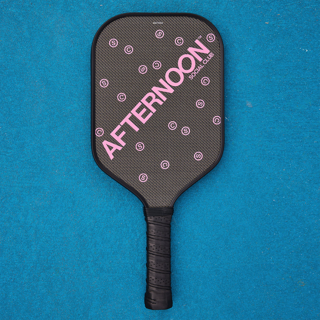 A black titan carbon pickleball paddle with the words Afternoon SC in purple